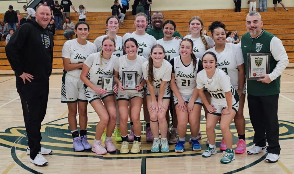 Photo of The Liberty Hawks celebrate at center court after defeating the Yosemite Badgers, 28-26, to win the first Liberty Hawks Holiday Classic on December 20 at Liberty. 