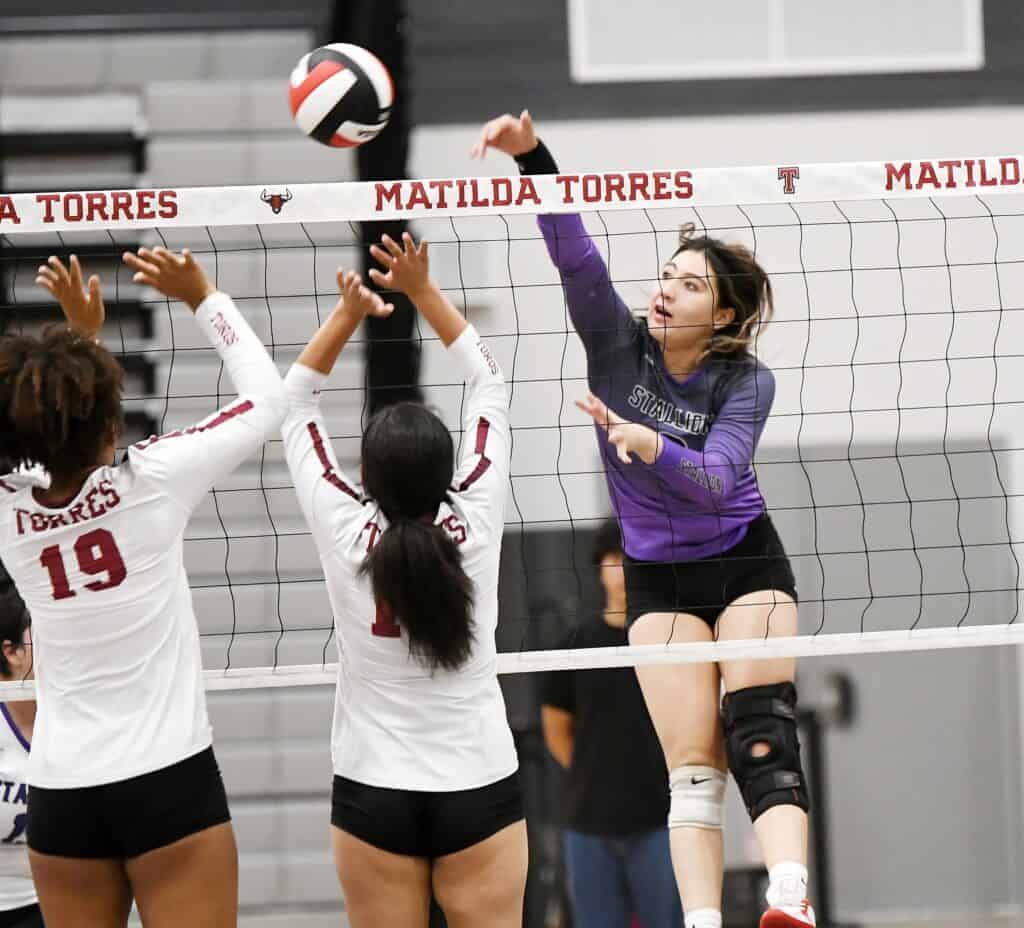 Photo - Madera South’s Jazlynn Vargas sends a kill attempt past the Toros’ block Aida Aquino during Tuesday’s three-set sweep over Torres.