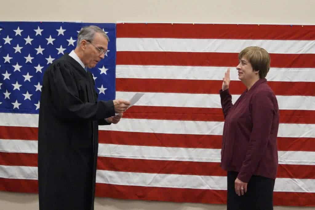 Photo - Cecilia Massetti takes an oath of office as Madera County superintendent of schools Monday at the county education conference center. At left, the Honorable Judge Mitchell Rigby performs the swearing-in ceremony.