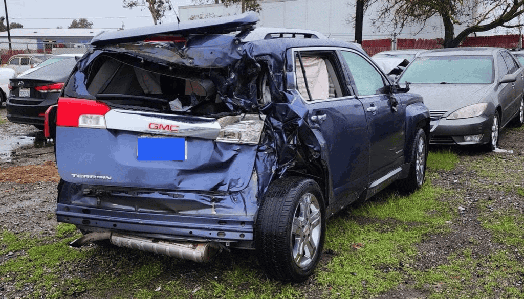 Photo - A GMC Terrain sits in a lot after it was hit in the back by a tractor-trailer Thursday morning on Avenue 12. The impact cause the Terrain to run into a Golden Valley Unified School District bus, which caused a couple of minor injuries.