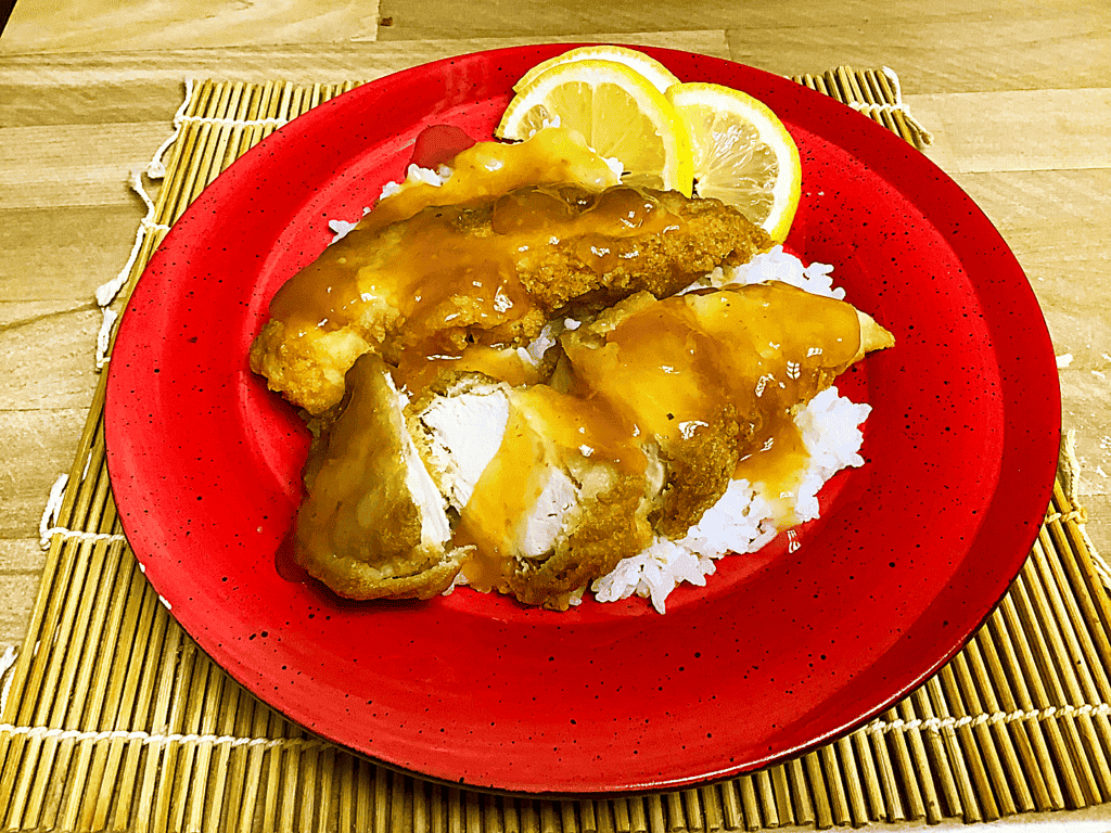 Photo - Serve lemon chicken with, or over, a bed of cooked, white rice, and garnish with a few lemon slices.