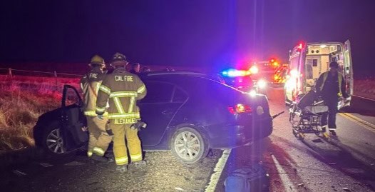 Photo of First responders take care of a vehicle that collided with another vehicle trying to make a U-turn on westbound State Route 145 on Sunday. A passenger in one of the vehicles died from her injuries.