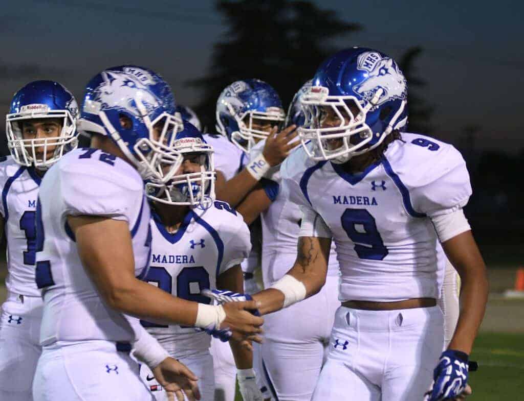 Photo - Madera’s Alex Vaca (72) congratulates Jevon Denis after he scored the first of his three touchdowns in Friday’s double overtime win over Selma.