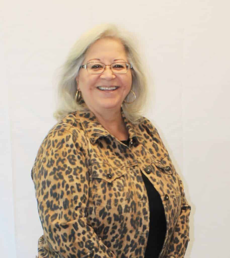Woman smiling in leopard print jacket for Madera Tribune article.