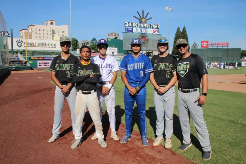Group of young baseball players standing on the field at Chuckchansi Park.