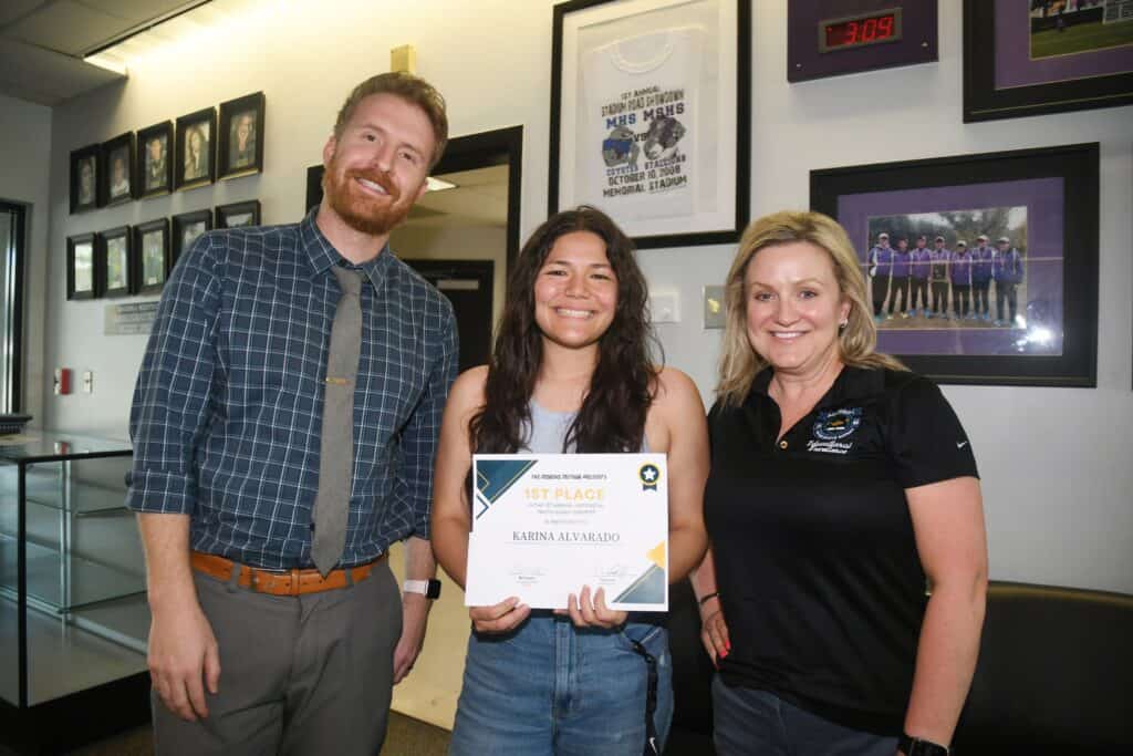 Young woman receiving award from Madera Tribune representatives.