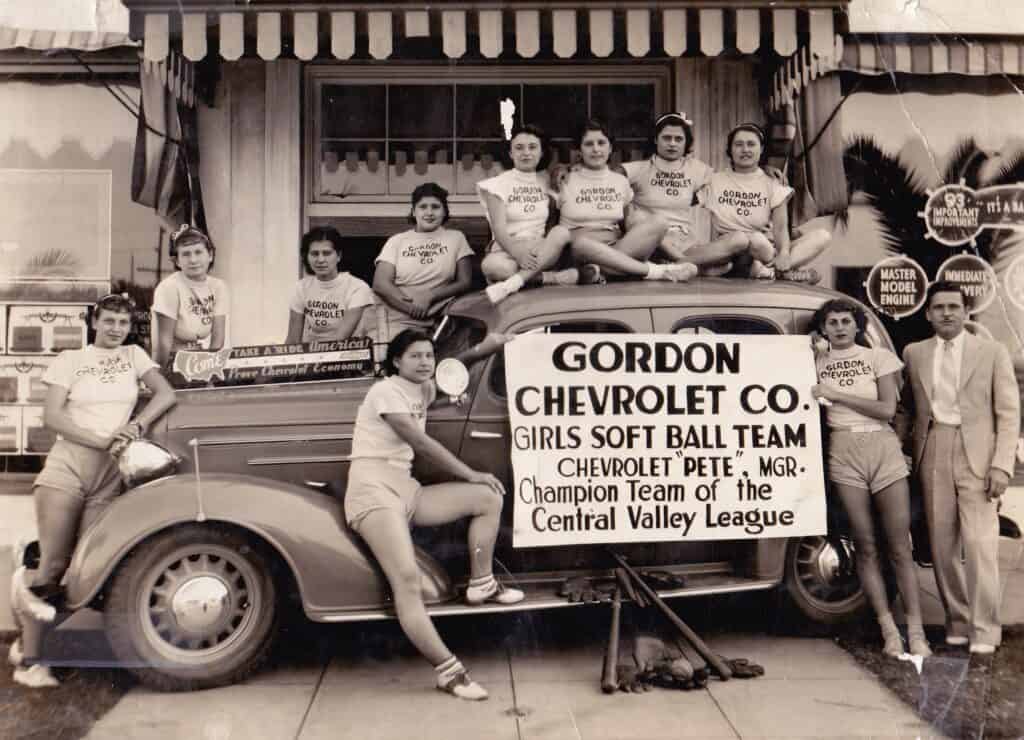 Vintage photo of Madera girls softball team with Chevrolet car.