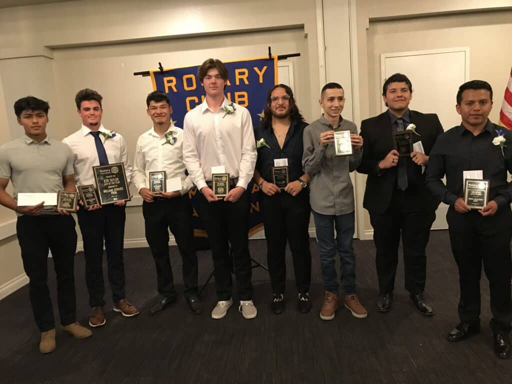 Group of young men receiving awards at Madera Rotary Club event.