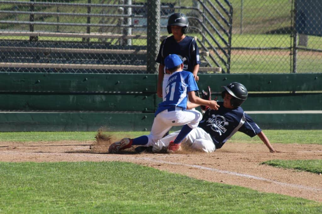 Young baseball players competing on the field during a game.