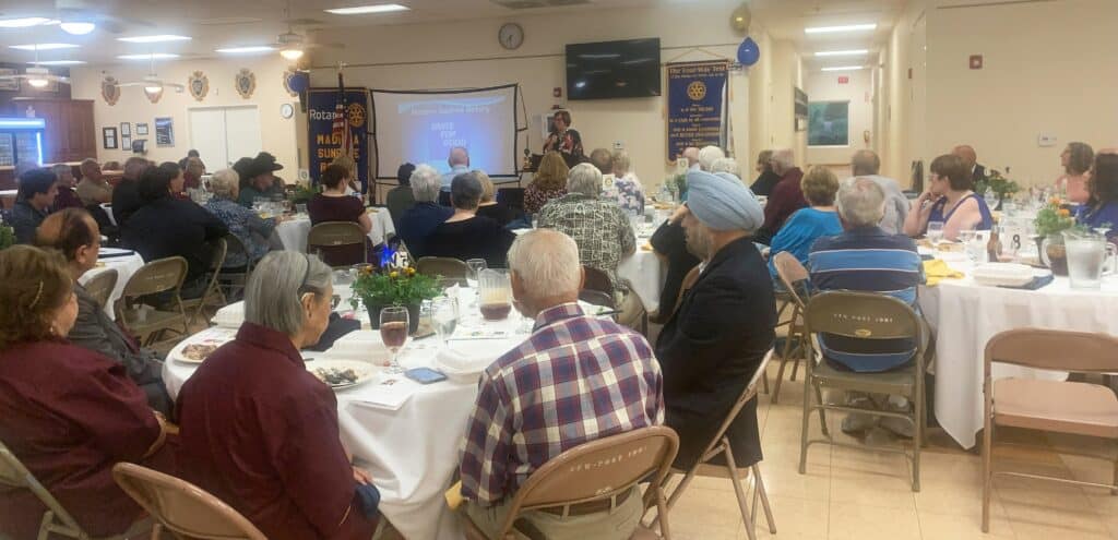 Community meeting with audience listening to a speaker at a local event.