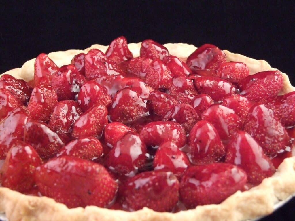 Delicious homemade strawberry pie topped with shiny glaze and fresh strawberries. Perfect for desser.