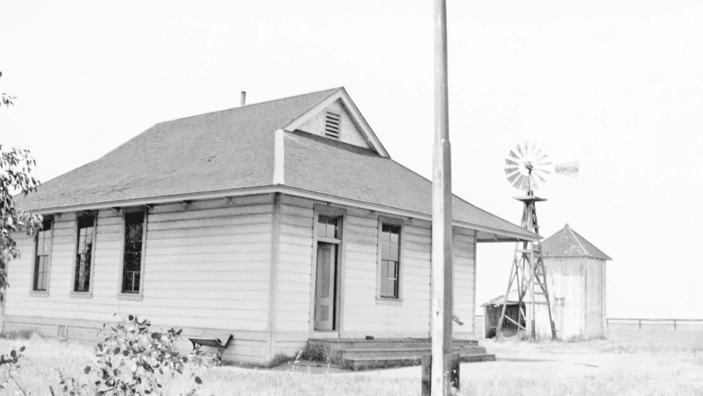 Old wooden house with windmill and water tower in rural Madera County.