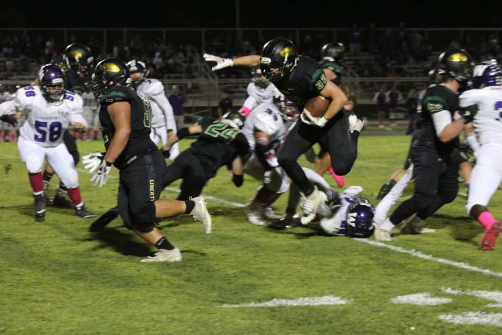 Madera high school football players in action during a night game.
