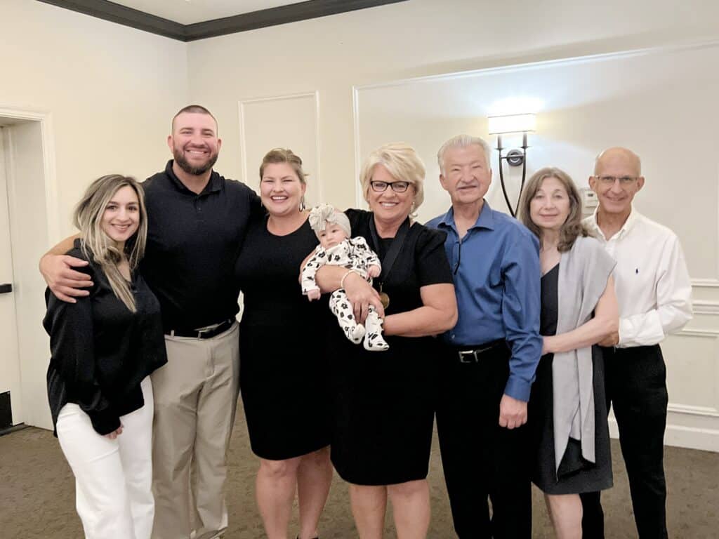 A happy family group gathered indoors, celebrating together at The Madera Tribune event.