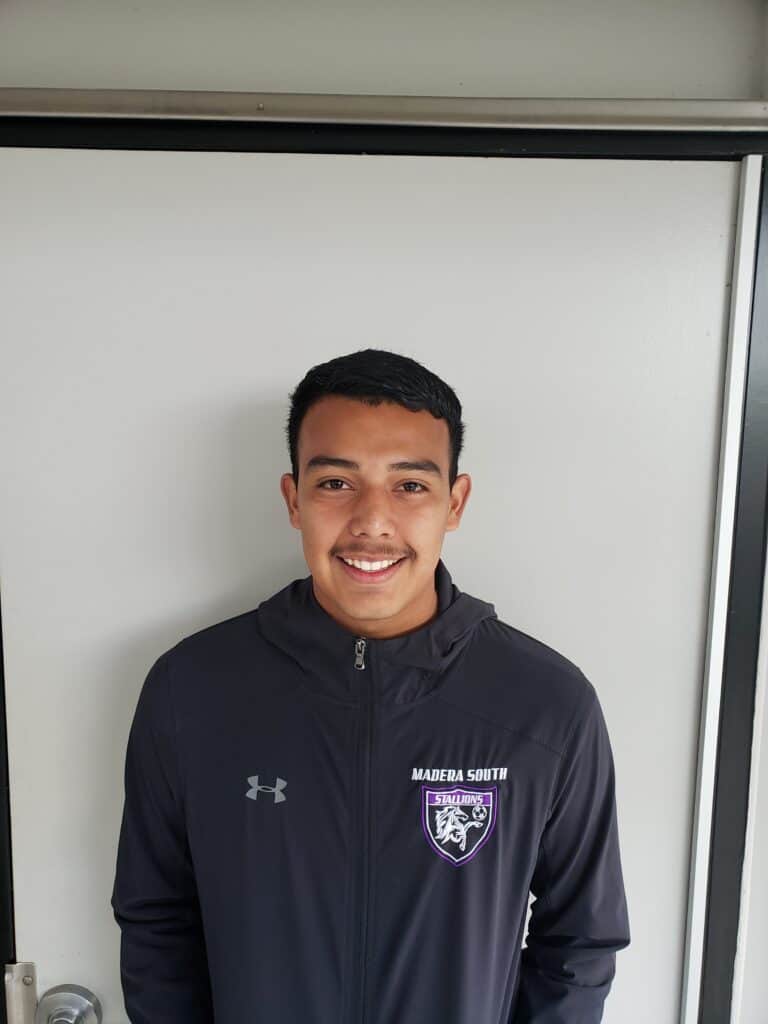 Madera South High School student smiling in a black jacket with school logo.