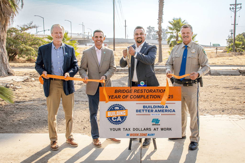 People holding scissors at a bridge opening event.