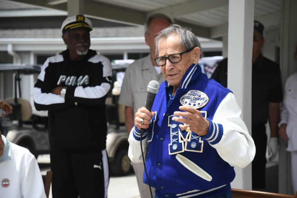 Elderly man speaking at community event in Madera, CA.