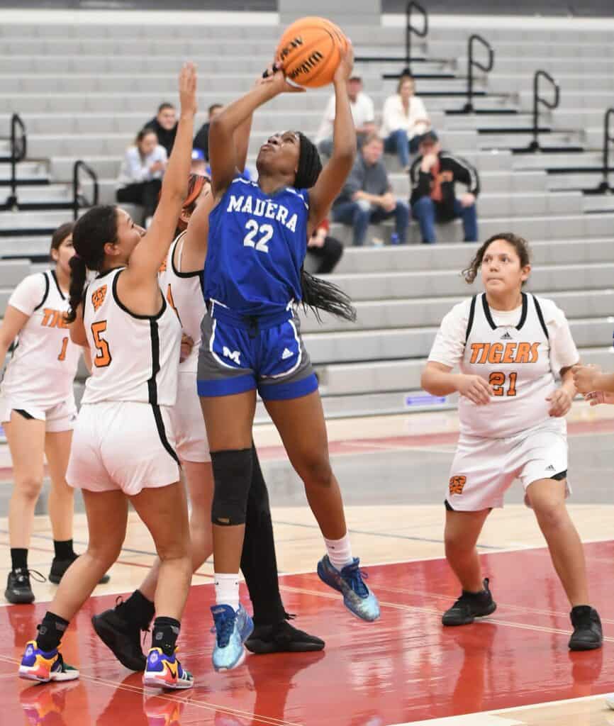 Madera girls' basketball players competing in a game at the gym.