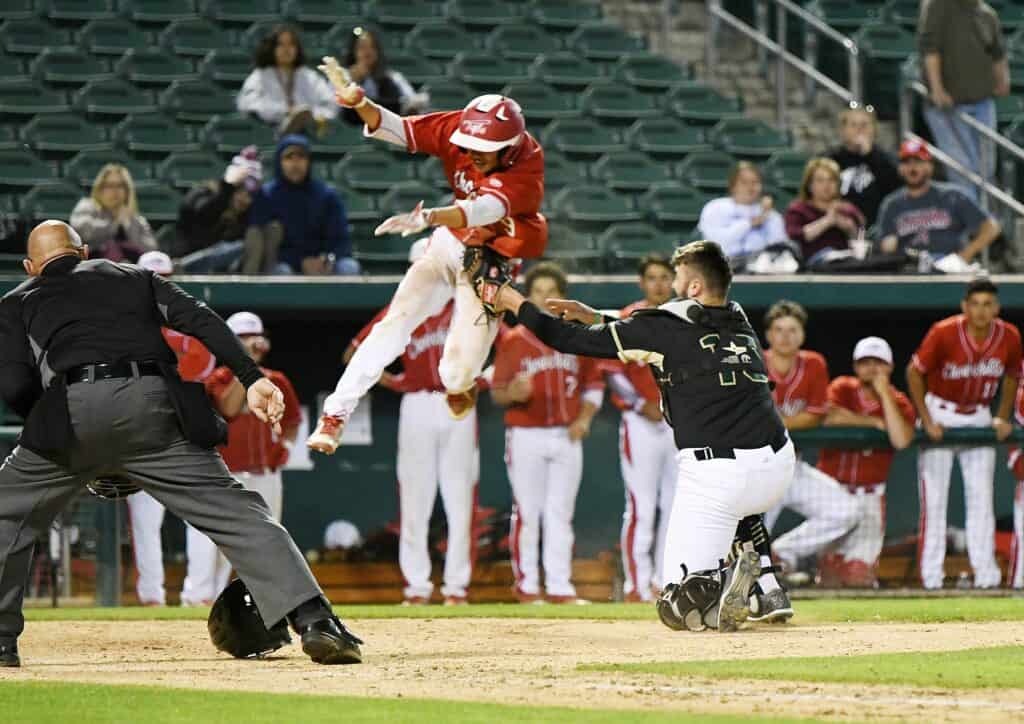 Player sliding into home plate during a baseball game.