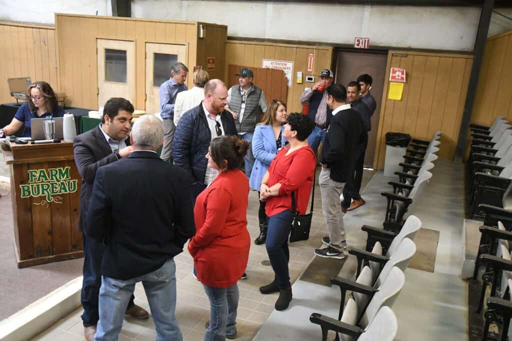 People engaging in discussion during local agriculture event.