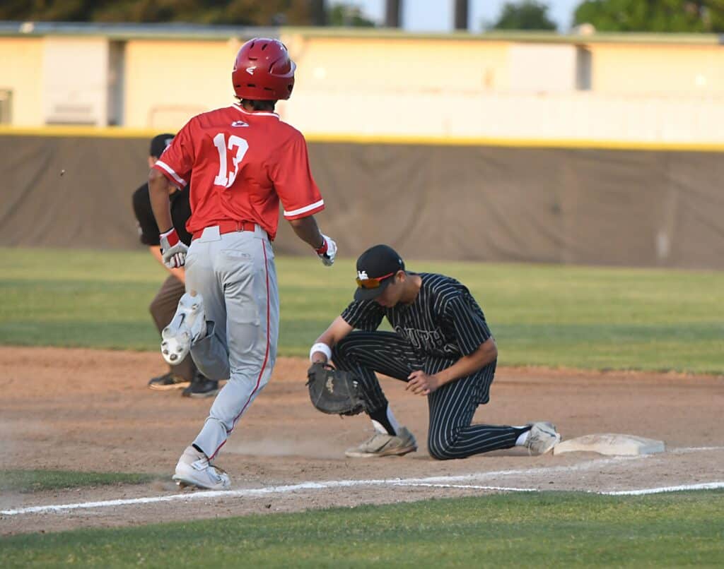 Young baseball player sliding into second base during game.