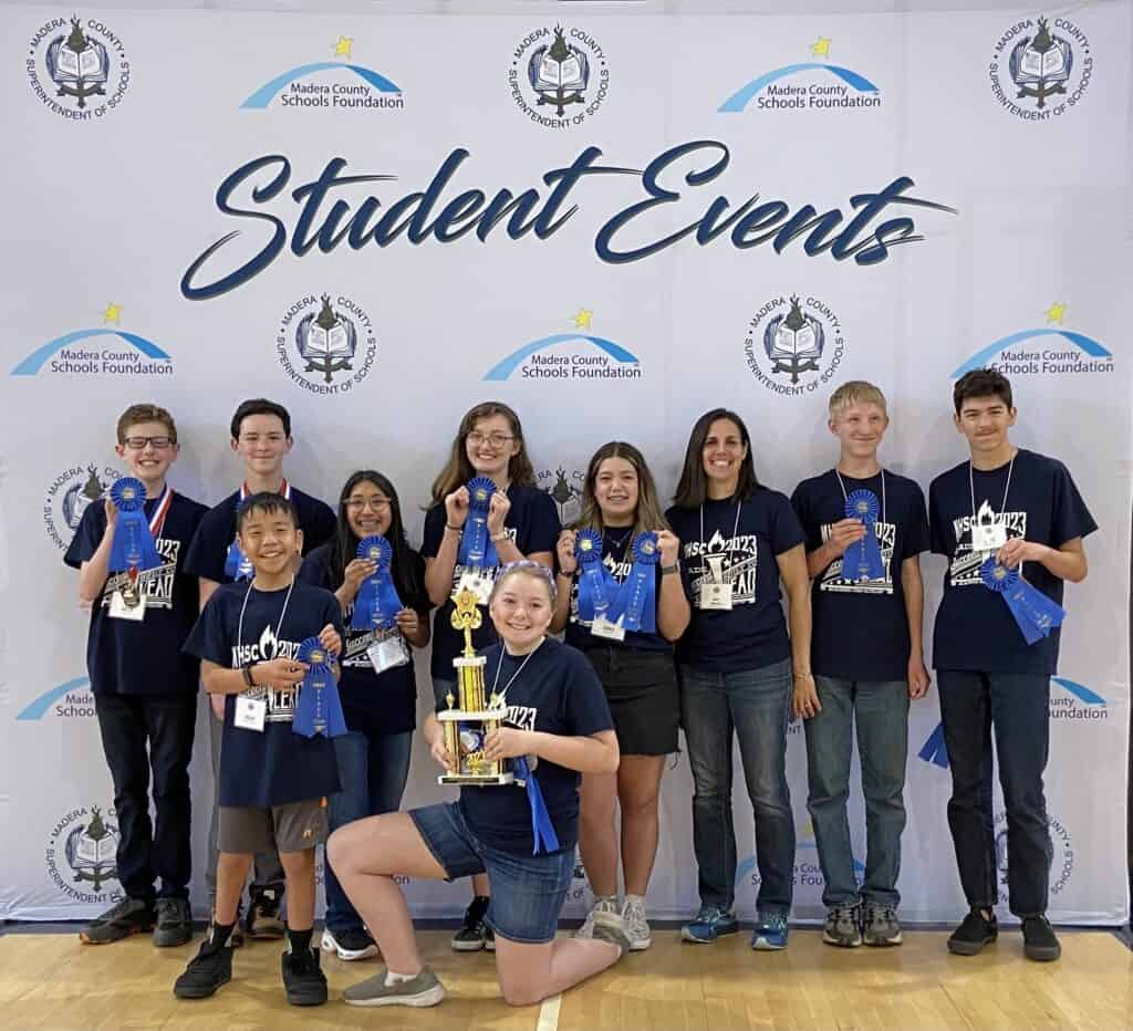 Group of students holding awards at Madera County Schools event.