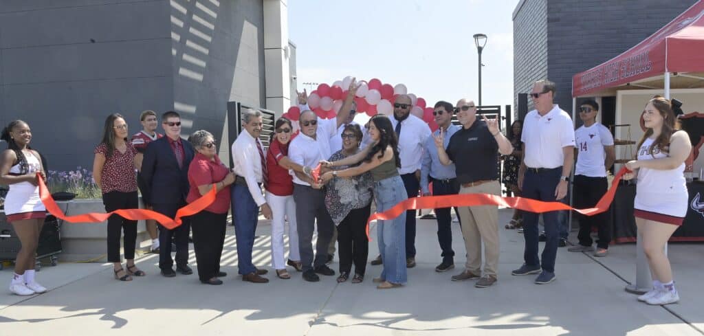 Group of people at ribbon-cutting event outside building in Madera.