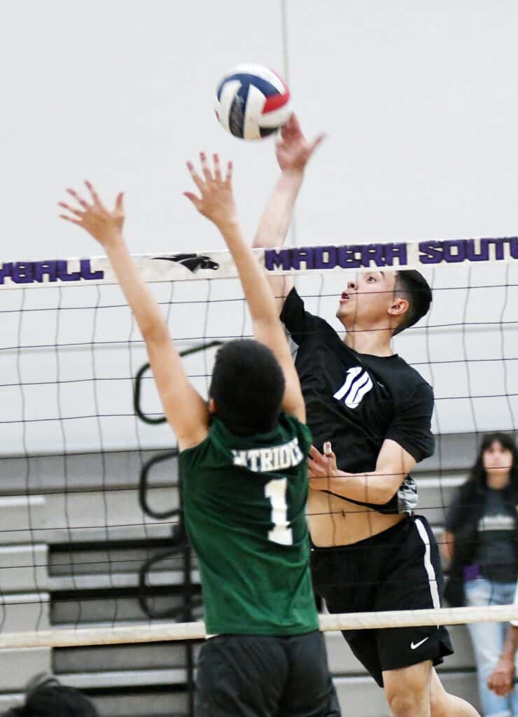 Volleyball player spiking ball at Madera South gym.