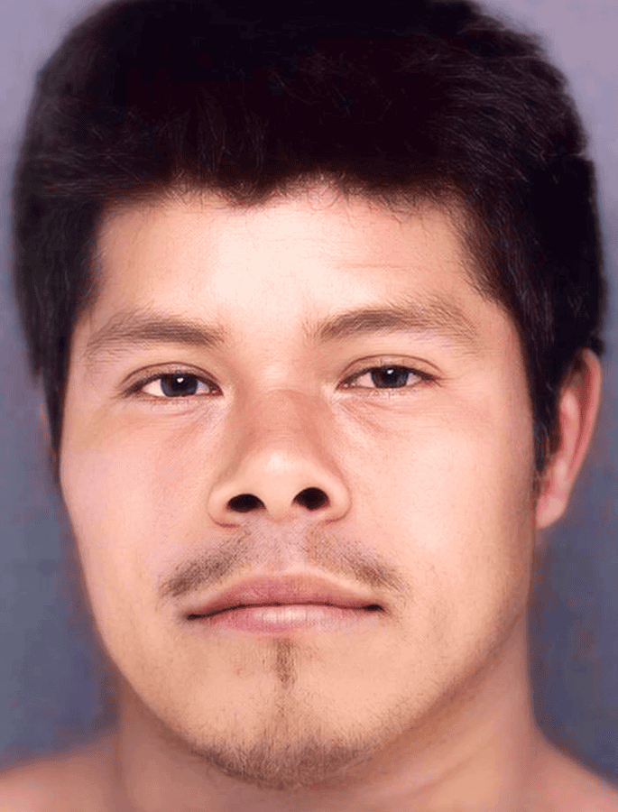 Young man with dark hair and light facial hair, looking directly at the camera.