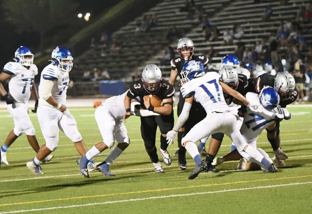 Madera high school football players in action during a game.