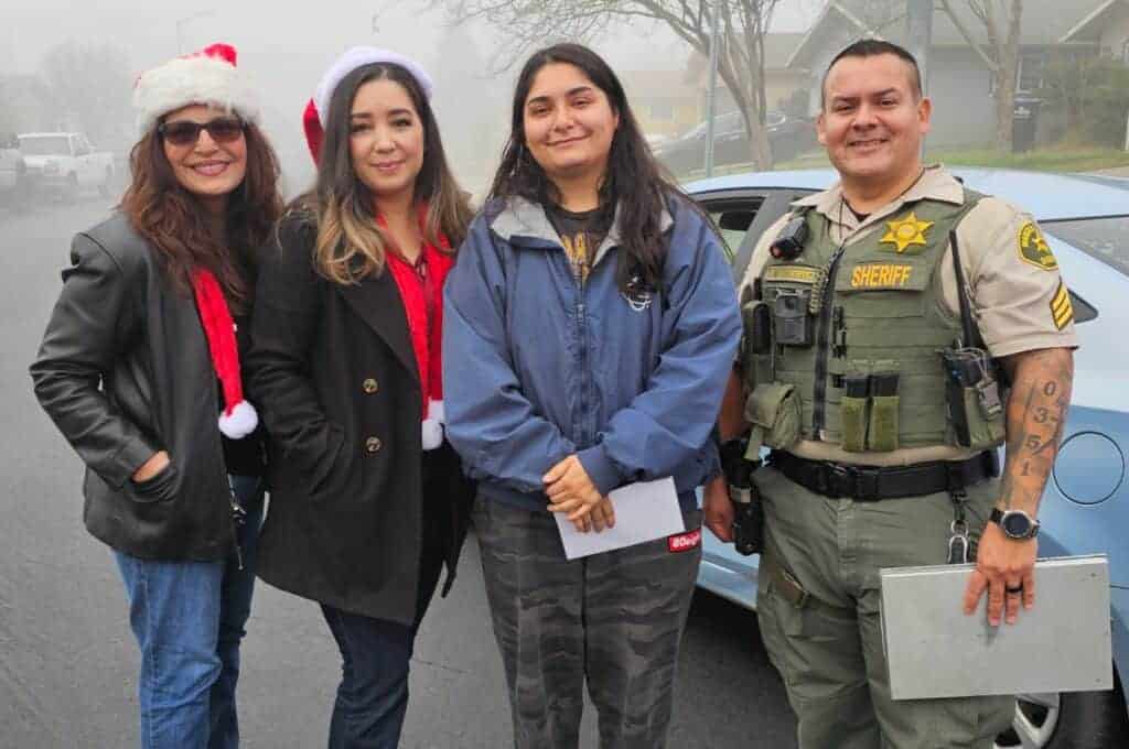 Photo - Jeannette Mejia is a recipient of a Random Act of Kindness distributed by, from left, Agriland employees Delilah Valenzuela and Ana Palafox and MCSO Sergeant Richard Gutierrez.