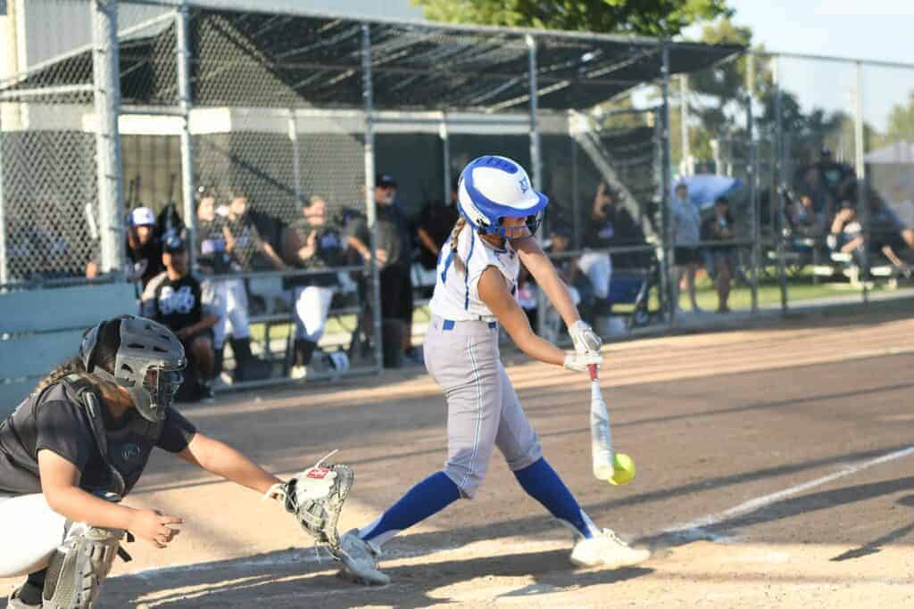 Photo - Madera’s Kaylee Patlan reaches down for one of her two hits in Thursday’s victory over the Madera South Stallions to help the Coyotes win the league championship.