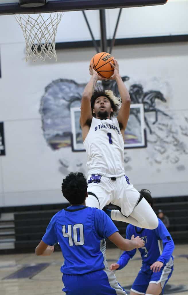 Young basketball player jumping for a shot during game.