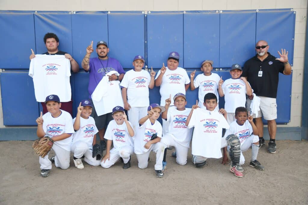 Madera youth baseball team with coaches after game.
