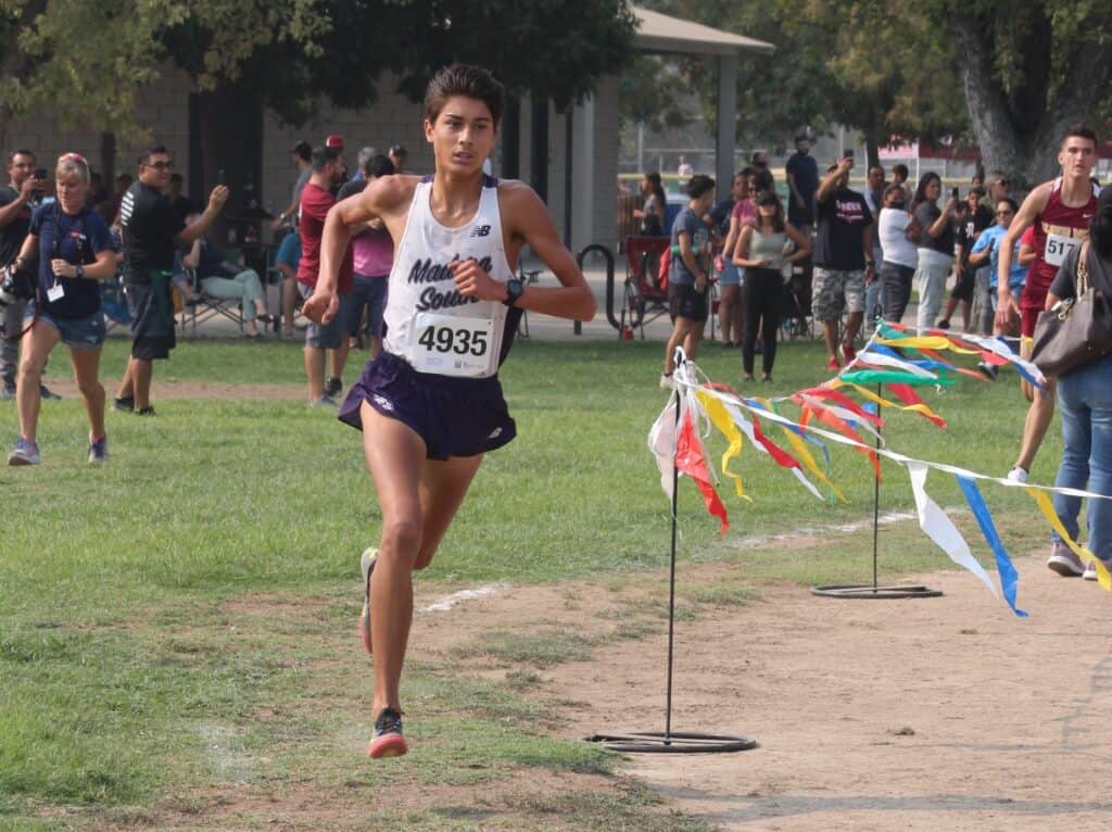 Young female athlete running in a community track event.