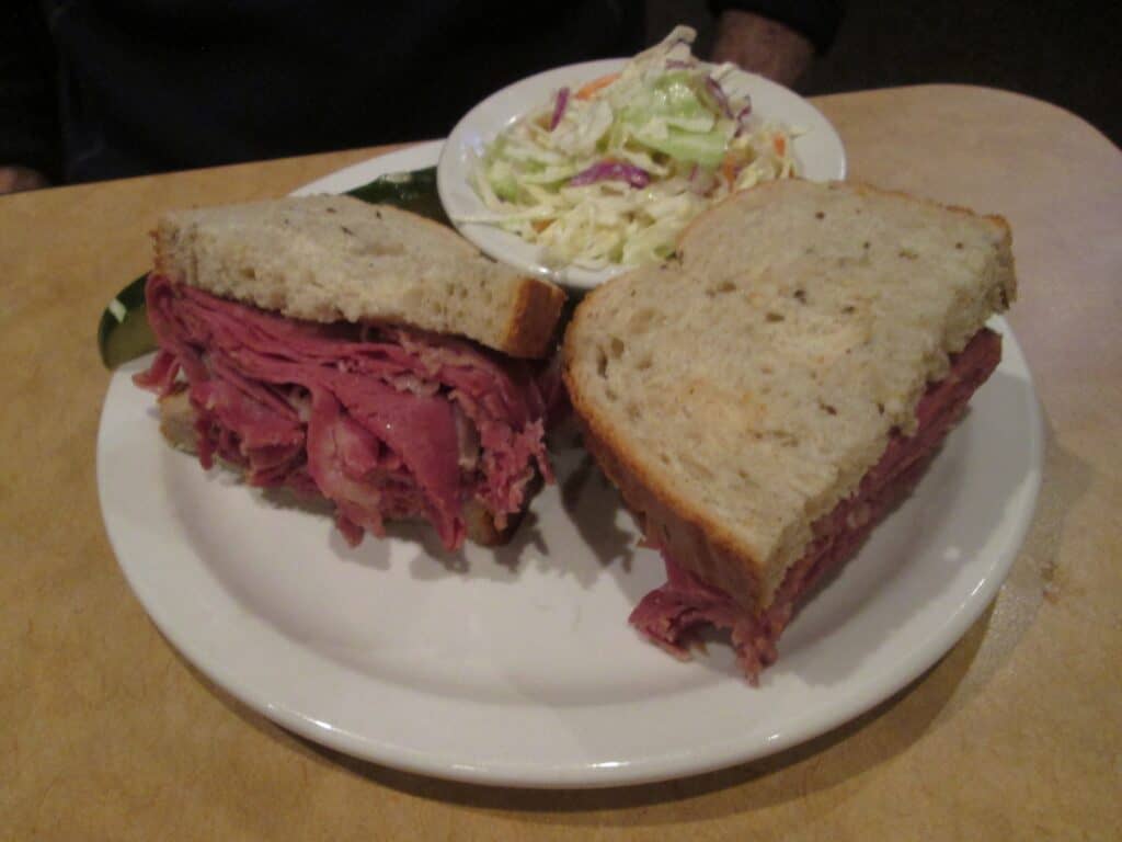 Roast beef sandwich with fresh bread and side salad.