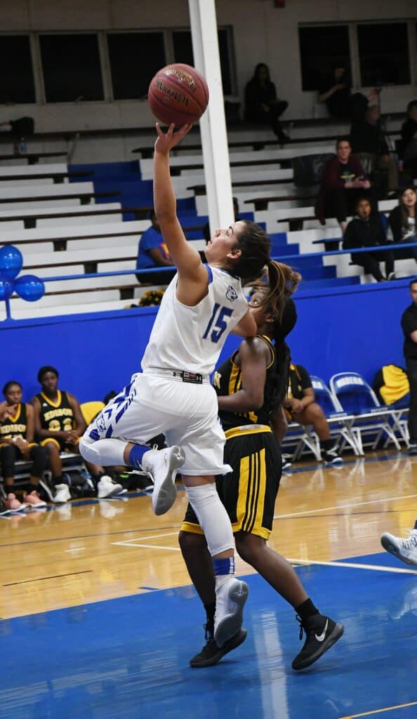 Female basketball player jumping for a shot during a game.