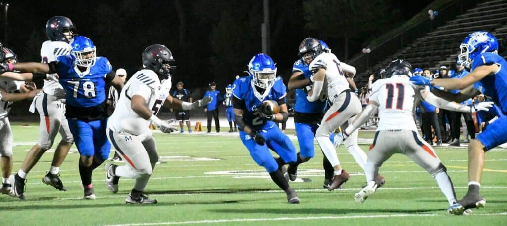 Madera High football players in action during a night game.