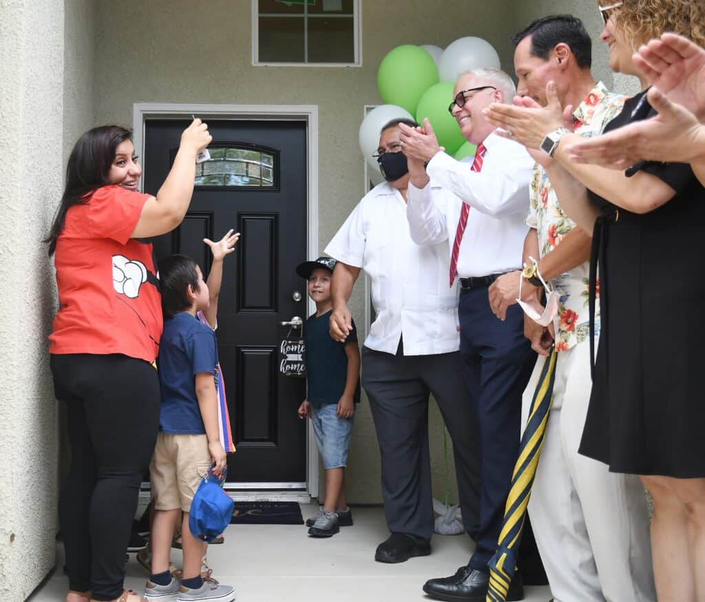 Community celebration with children and adults at a new home opening.