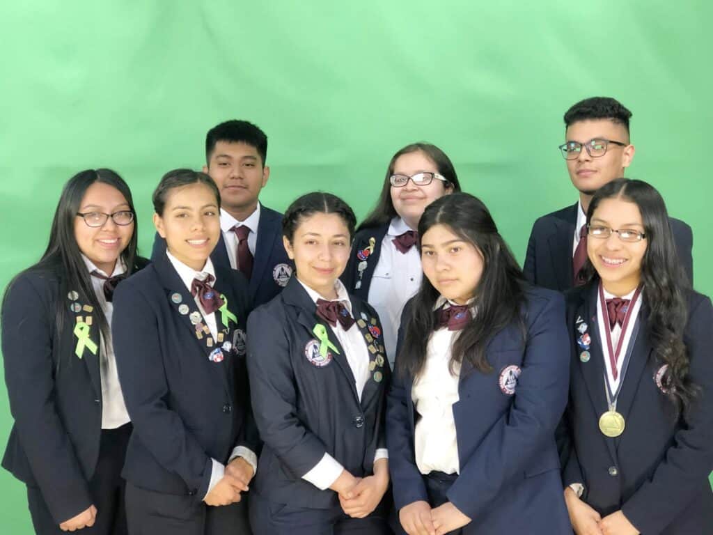 Group of diverse students in school uniforms with medals and ribbons.