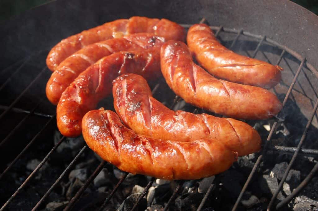 Sizzling sausages cooking on a grill, ready to enjoy at a barbecue event.