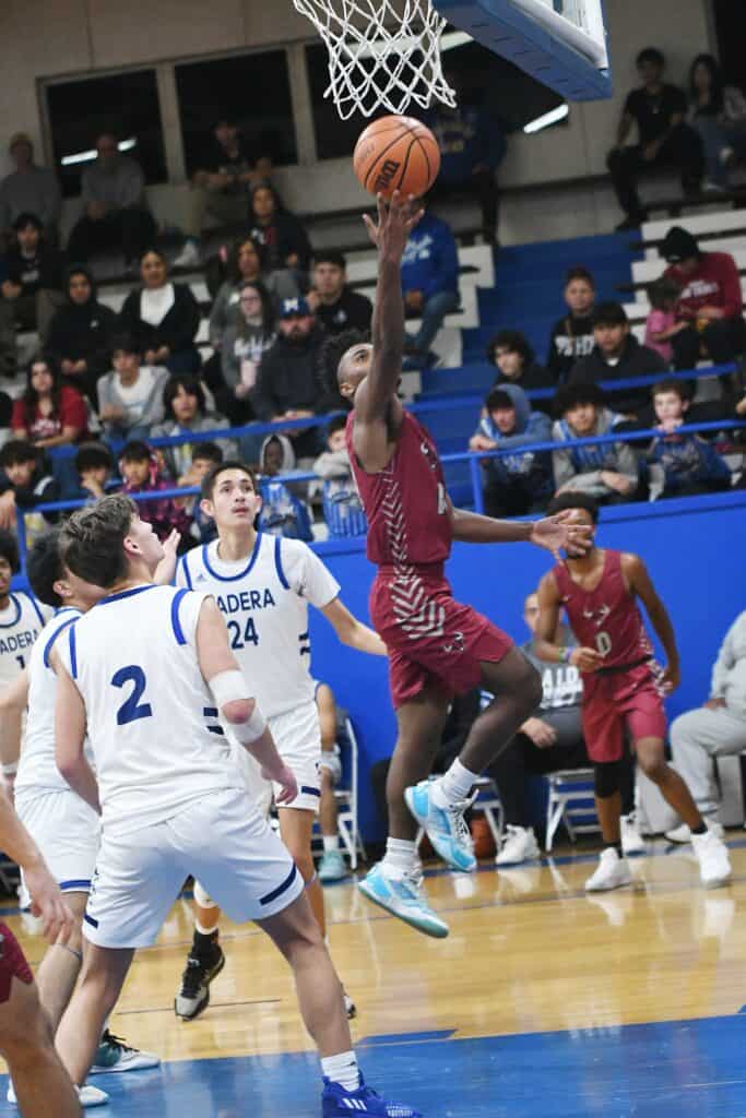 Young basketball player going for a layup during game.