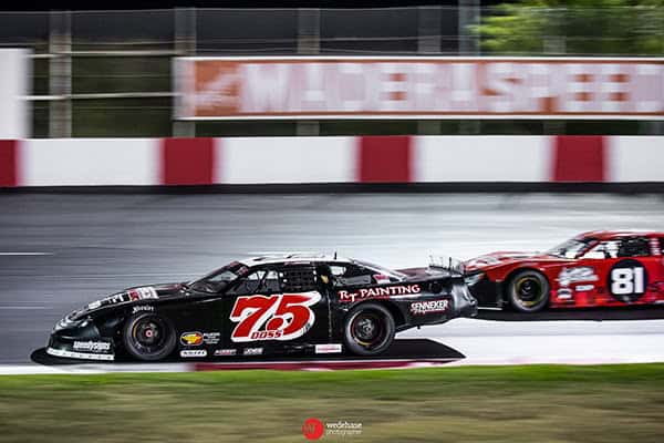 High-speed race cars on a track, showcasing competitive racing action.