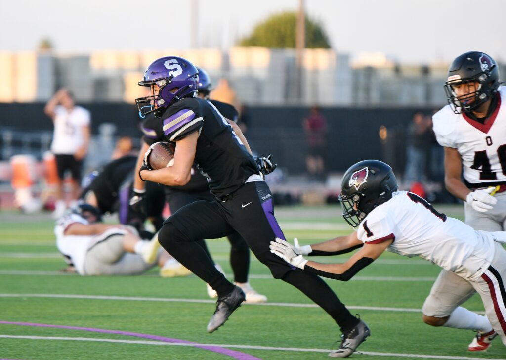 Photo - Madera South’s Justin Caballero breaks a tackle to score the first touchdown of the season for the Stallions during Friday’s loss to the Orosi Cardinals.