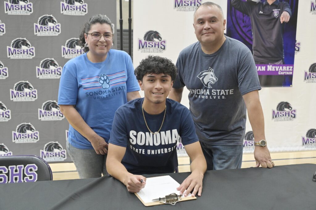 Photo - Madera South’s Julian Nevarez, with his parents, are all smiles after signing his National Letter of Intent to play soccer at Sonoma State University. 