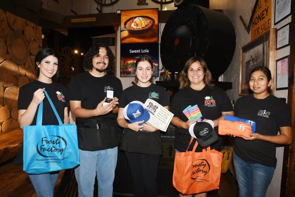 Group of young people holding charity items at local event.
