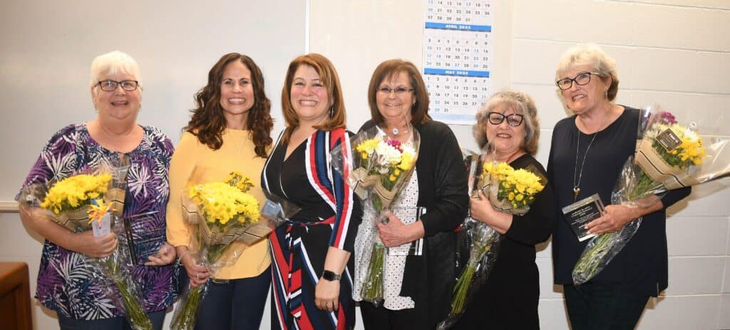 Group of women holding flowers at Madera Tribune event.