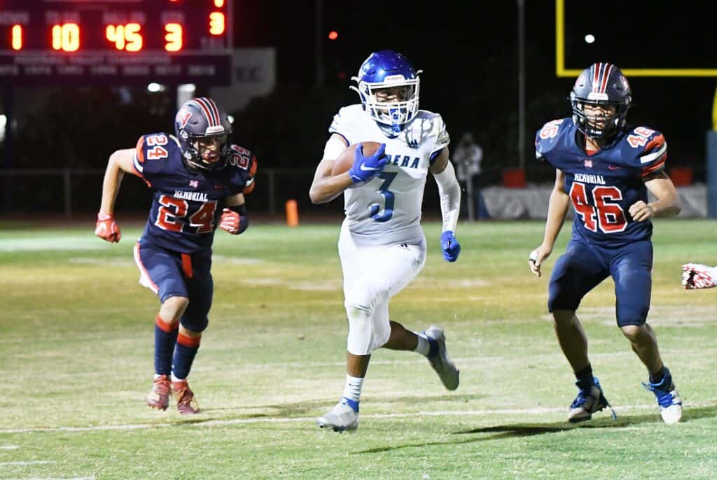 Madera football players in action during a night game.