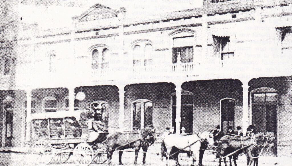Historic Madera Tribune building with horse-drawn carriages outside.