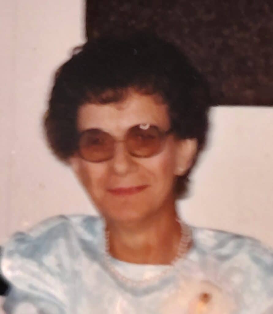 Historic photo of a woman wearing sunglasses and a pearl necklace.